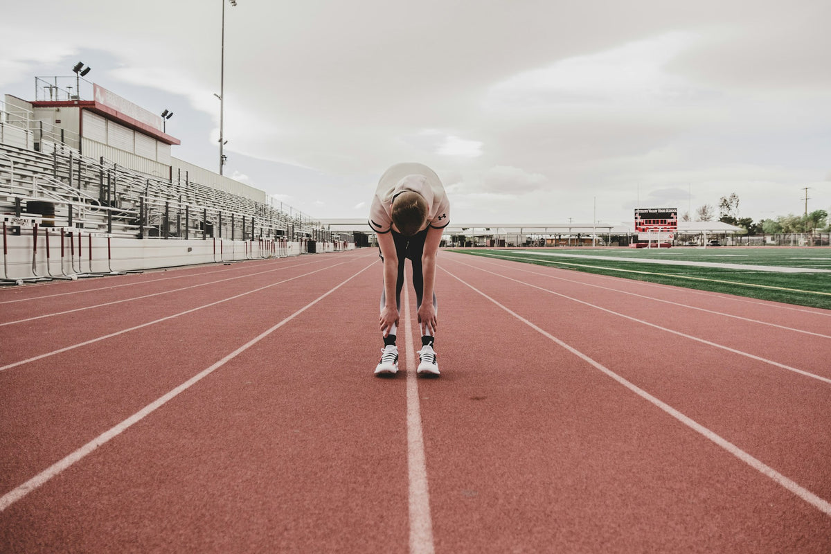 Person at the starting line of a running track on a cloudy day